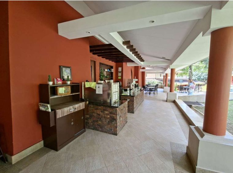 Barra de cafetería bajo un portal techado con columnas color terracota