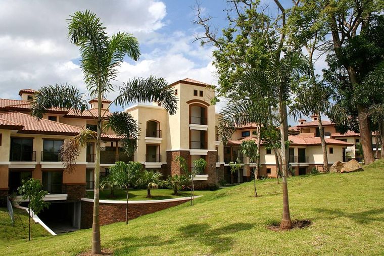 Edificios Garden de techos de teja entre palmeras y jardines en pendiente